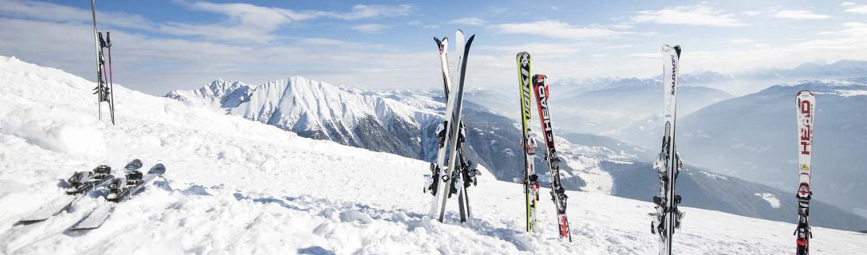 skis planté dans la neige en haut d'une montagne